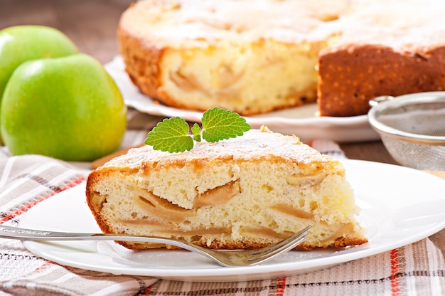 Foto scheibe apfelfruchtkuchen auf einem teller mit minzblatt verziert