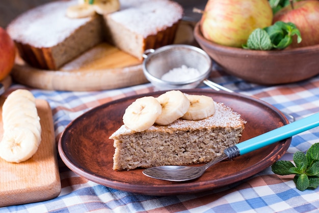 Scheibe Bananenkuchen auf einem Teller auf einem hölzernen Hintergrund