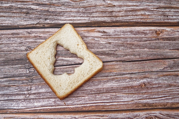 Scheibe Brot in Form eines Weihnachtsbaumes auf Holztisch geschnitten