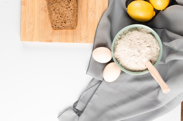 Scheibe Brot, Mehl und Eier auf dem Tisch