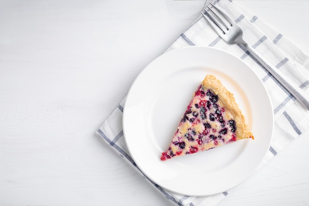 Scheibe der Blaubeer- und Johannisbeertorte auf rustikalem Holztisch