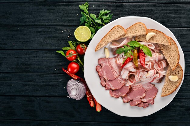 Scheibe geräuchertes Fleisch auf einem Teller Auf einem hölzernen Hintergrund Ansicht von oben Kopieren Sie Platz