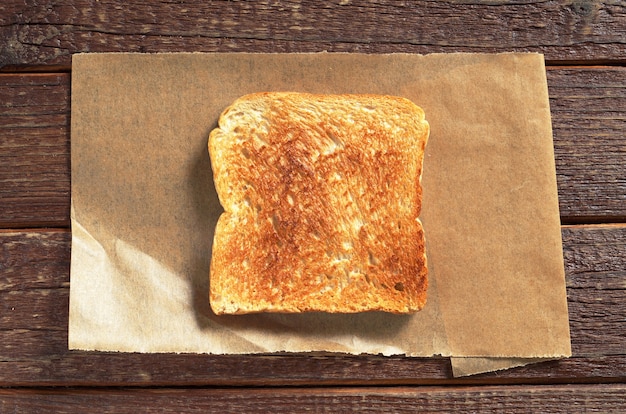 Scheibe geröstetes Brot auf Holztisch