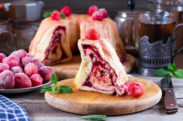 Scheibe hausgemachten Hefekuchen mit Marmelade auf einem alten Holztisch