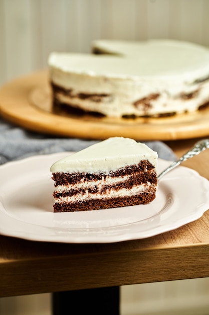 Scheibe hausgemachten Schokoladenkuchen auf Teller. Holzhintergrund