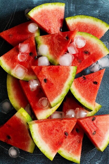 Scheiben der frischen Wassermelone mit Eis auf einem blauen Beton