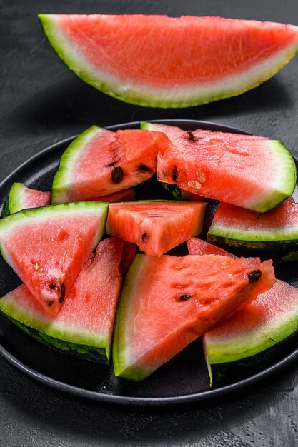 Scheiben der reifen Wassermelone in einer Platte auf Dunkelheit