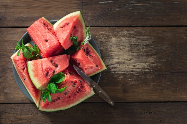 Scheiben der saftigen reifen Wassermelone auf einem Schneidebrett auf einem Holztisch