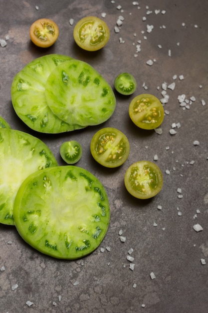 Scheiben grüne Tomaten. Rostiger Metallhintergrund. Flach legen