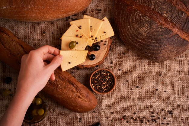 Scheiben Käse auf hölzernem Schreibtisch zwischen verschiedenen Broten