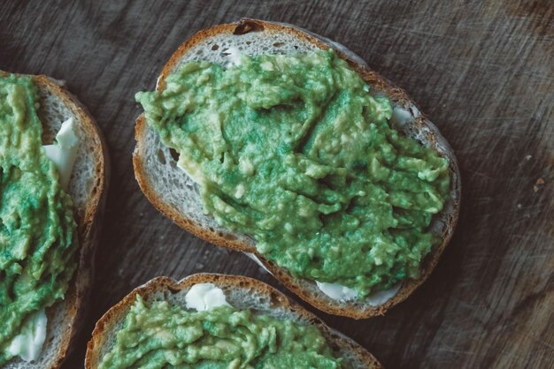 Scheiben Roggenbrot mit Avocado auf einem einfachen rustikalen Sandwich aus Holz