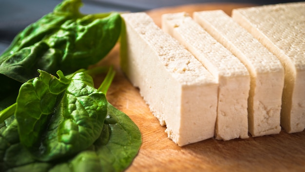 Scheiben roher Tofu und Spinat