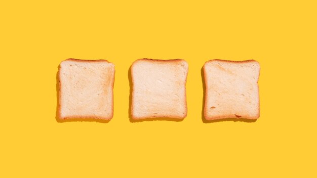 Scheiben Toastbrot auf gelbem Hintergrund