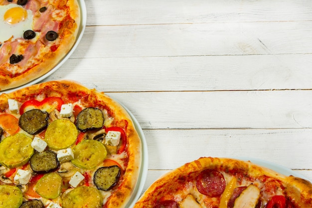 Scheiben verschiedener Pizzasorten auf weißem Hintergrund