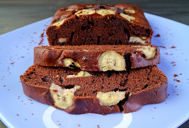 Scheiben von aromatischem frisch gebackenem hausgemachtem dunklem Schokoladenbananenkuchen auf einem Teller