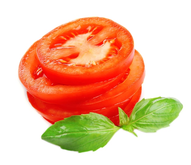Foto scheiben von frischen tomaten mit basilikum, isoliert auf weiss