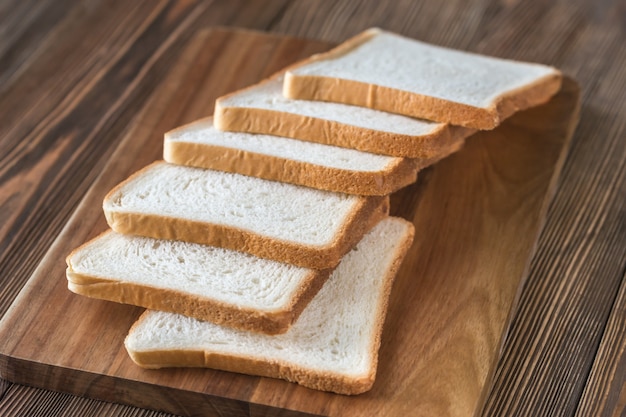 Scheiben Weißbrot auf einem Holzbrett