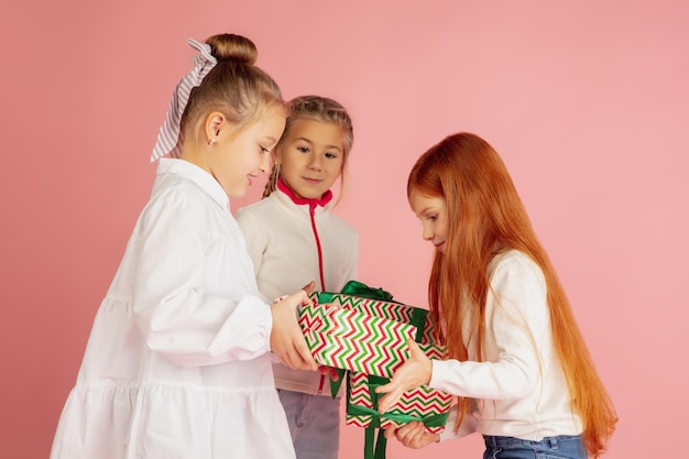 Schenken und Beschenken an den Weihnachtsfeiertagen. Gruppe glücklicher lächelnder Kinder, die Spaß haben