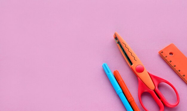 Scherenstifte auf einem rosa Hintergrund Schule oder Büroarbeitsplatz mit Zubehör für Handwerk