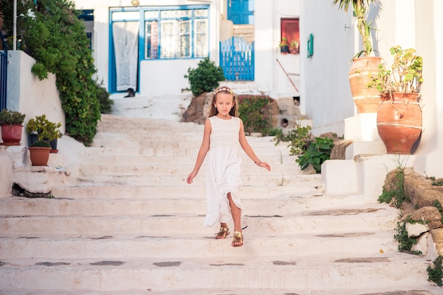 Scherzen Sie an der Straße des typischen griechischen traditionellen Dorfs mit weißen Wänden und bunten Türen auf Mykonos-Insel