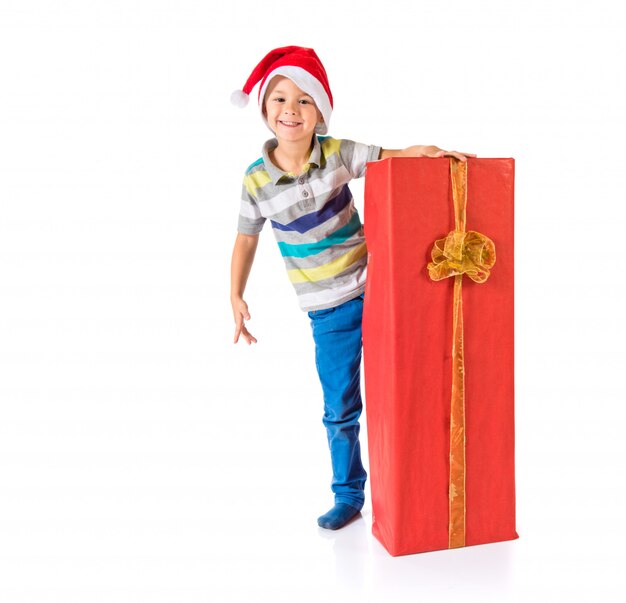 Scherzen Sie mit dem Weihnachtshut, der ein großes rotes Geschenk hält. Weihnachts-Konzept