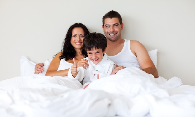 Scherzen Sie mit den Daumen oben und seinen Eltern im Bett