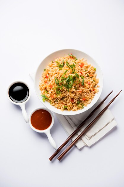 Schezwan Fried Rice Masala é uma comida indo-chinesa popular servida em um prato ou tigela com pauzinhos. foco seletivo