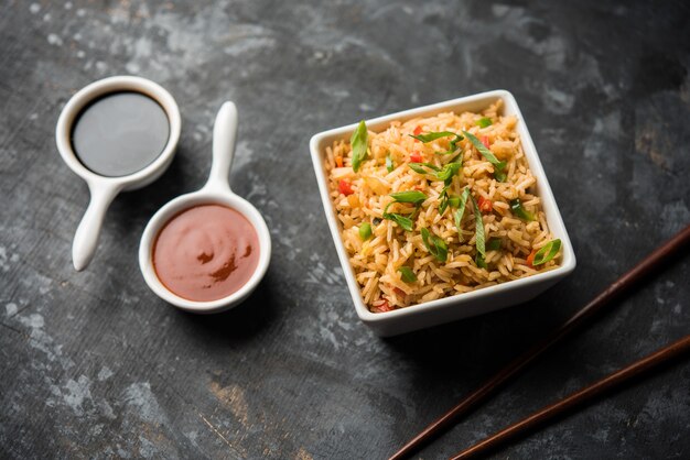 Schezwan Fried Rice Masala é uma comida indo-chinesa popular servida em um prato ou tigela com pauzinhos. foco seletivo