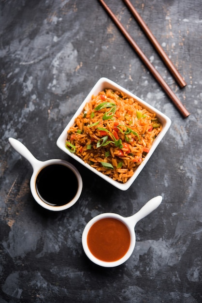 Schezwan Fried Rice Masala é uma comida indo-chinesa popular servida em um prato ou tigela com pauzinhos. foco seletivo