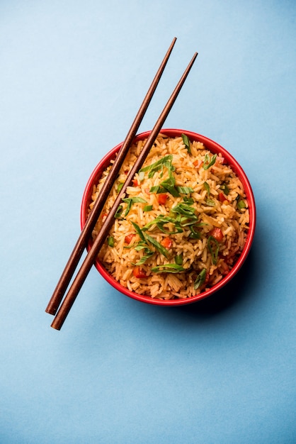 Schezwan fried rice masala é uma comida indo-chinesa popular servida em um prato ou tigela com pauzinhos. foco seletivo