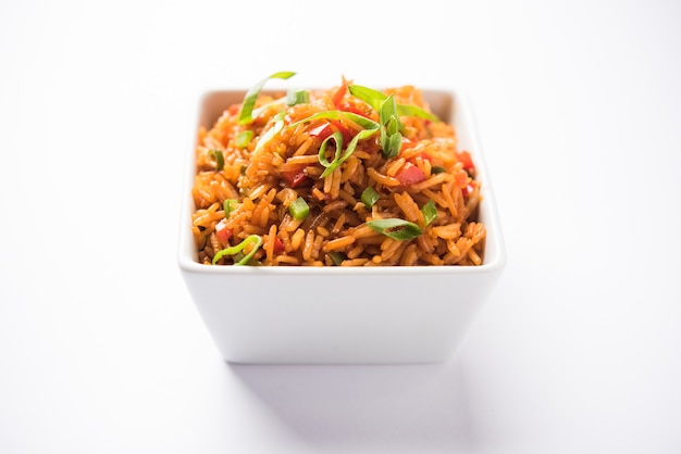 Schezwan Fried Rice Masala é uma comida indo-chinesa popular servida em um prato ou tigela com pauzinhos