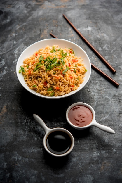 Schezwan Fried Rice Masala é uma comida indo-chinesa popular servida em um prato ou tigela com pauzinhos