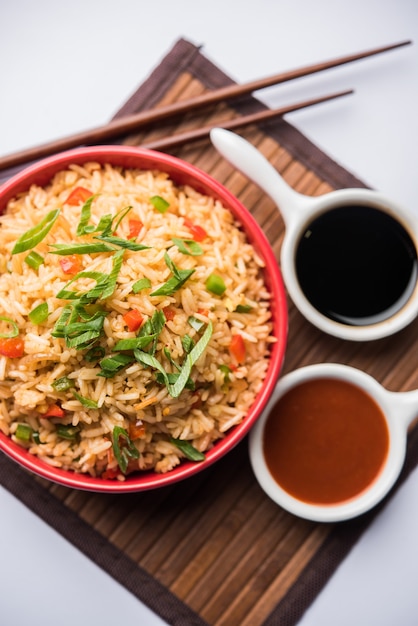 Schezwan Fried Rice Masala ist ein beliebtes indochinesisches Essen, das in einem Teller oder einer Schüssel mit Stäbchen serviert wird