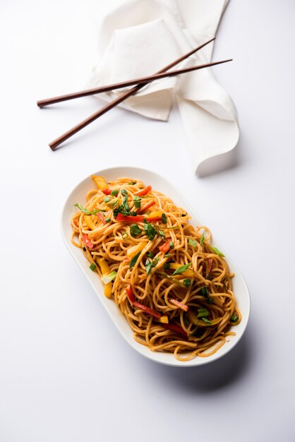 Schezwan-Nudeln oder Gemüse-Hakka-Nudeln oder Chow Mein ist ein beliebtes indo-chinesisches Rezept, serviert in einer Schüssel oder einem Teller mit Holzstäbchen