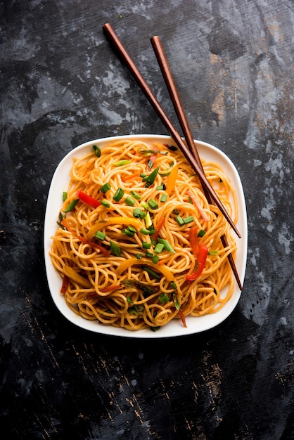 Schezwan-Nudeln oder Gemüse-Hakka-Nudeln oder Chow Mein ist ein beliebtes indo-chinesisches Rezept, serviert in einer Schüssel oder einem Teller mit Holzstäbchen