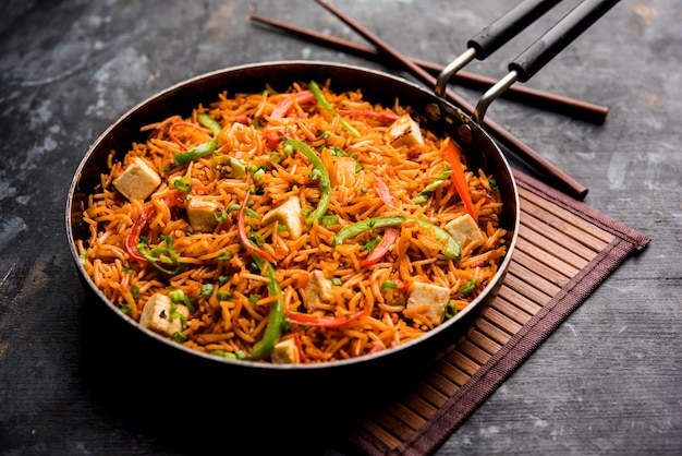 Schezwan paneer arroz frito com molho Szechuan e cubos de queijo cottage. servido em uma tigela ou prato ou panela. foco seletivo