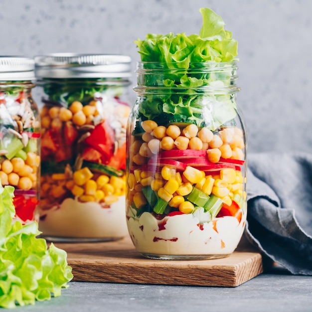 Schichtsalat im Glas Frischer Rettich, Gurke, Sellerie, rote Paprika, Mais, Kichererbsen und Soße