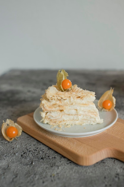 Schichttorte auf einem mit Physalis dekorierten Teller