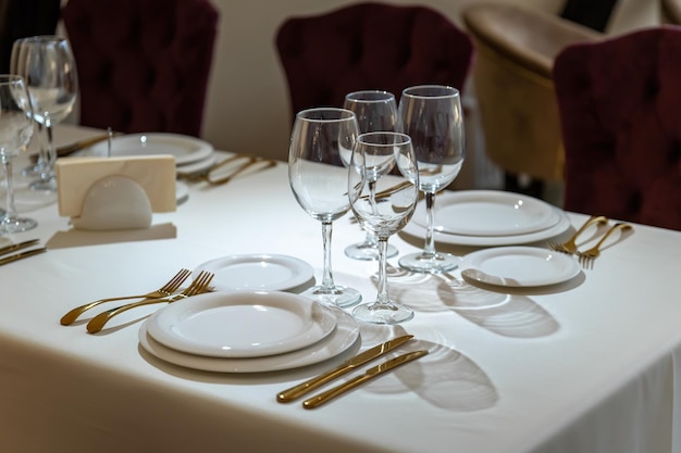 Schickes und elegantes vergoldetes Besteck und weiße Teller Tischdekoration mit leeren Tellern
