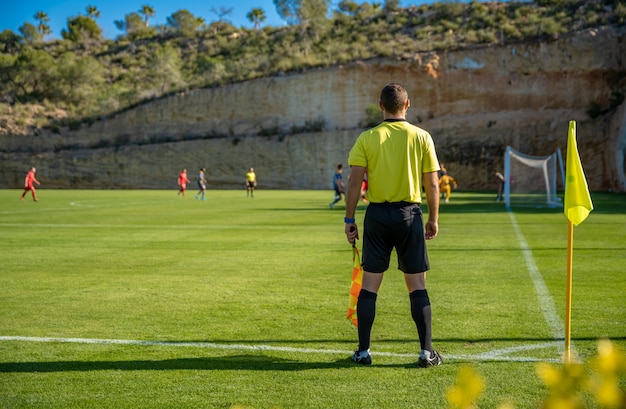 Schiedsrichterassistent in einem Fußballspiel, das das Spiel beobachtet