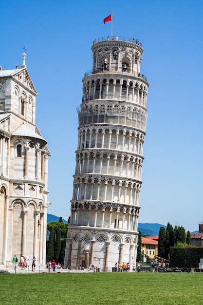 Schiefer Turm mit einem religiösen Gebäude daneben