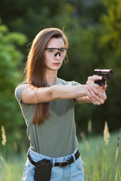 Schießlehrerin mit einer Waffe in der Hand, die auf das Ziel zielt