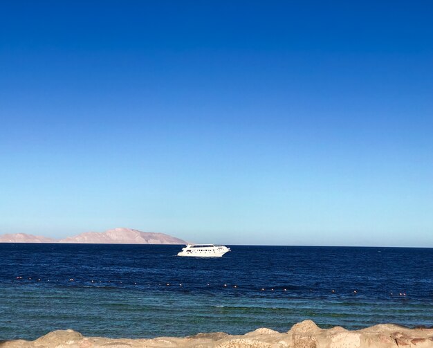 Schiffsyachtboot auf Horizontlinie Ägypten. Panoramablick auf die blaue Meeresoberfläche weit von der Küste entfernt.