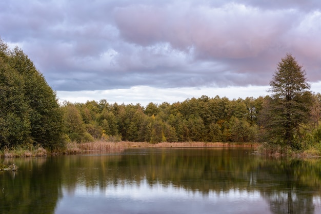 Schilf, Gras, Bäume und türkisfarbenes Wasser eines heilenden Sees. Herbstlandschaft. Früher Herbstmorgen auf dem Blauen See in Kasan. Russland.