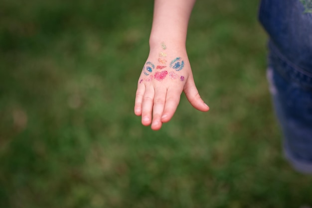 Schimmerndes funkelndes Glitzertattoo auf einer Kinderhand bei einer Geburtstagsfeier