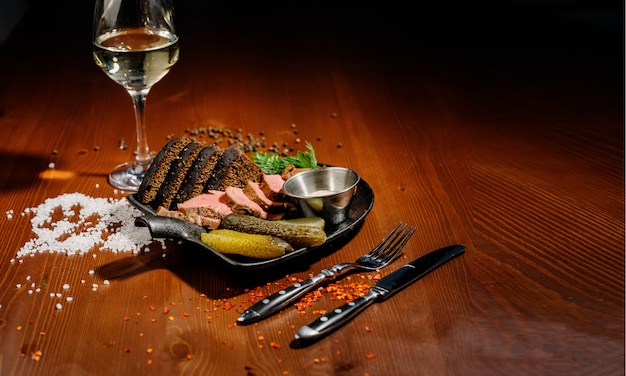 Foto schinken mit brot und gurken auf teller. draufsicht