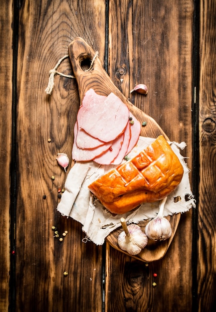 Schinken mit Knoblauch und Gewürzen auf dem alten Brett.