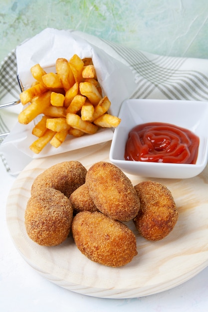 Schinken- und Hühnerkroketten mit Pommes Frites und gebratenen Tomaten