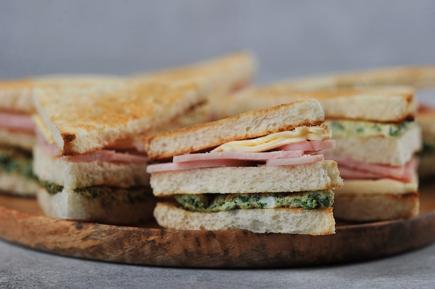 Schinken- und Käsesandwich auf einer hölzernen Platte