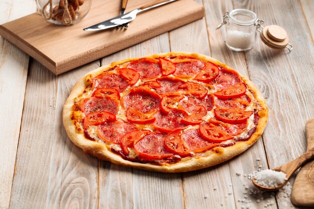 Schinkenpizza mit Tomate mit getrockneten Kräutern